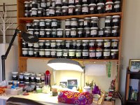 Dye shelf  My egg writing desk and all my jars of dye!  This is where I spend most of my time, so this is about as neat and tidy as it gets!  I store the mixed dyes in wide mouth mason jars, plastic tops are my favourite because they don't rust.  My lamp is a daylight model which really helps when working through the long winter months.  I use a microbead pillow to cushion the egg as I work, and behind that is my Petit wax warmer which allows me to always have hot, liquid wax.  The wooden stand to the right was made by Rob Terry and it holds all my kistky writing styluses, I normally use six but the stand will hold up to ten.       google_ad_client = "ca-pub-5949678472174861"; /* Gallery Photo Small */ google_ad_slot = "5716546039"; google_ad_width = 320; google_ad_height = 50; //-->    src="//pagead2.googlesyndication.com/pagead/show_ads.js"> : pysanky pysankybysojeo sojeo studio craftroom makeover organization storage diy eggshells egg eggs epoxy etching renovations varnishing booth fume dust collector